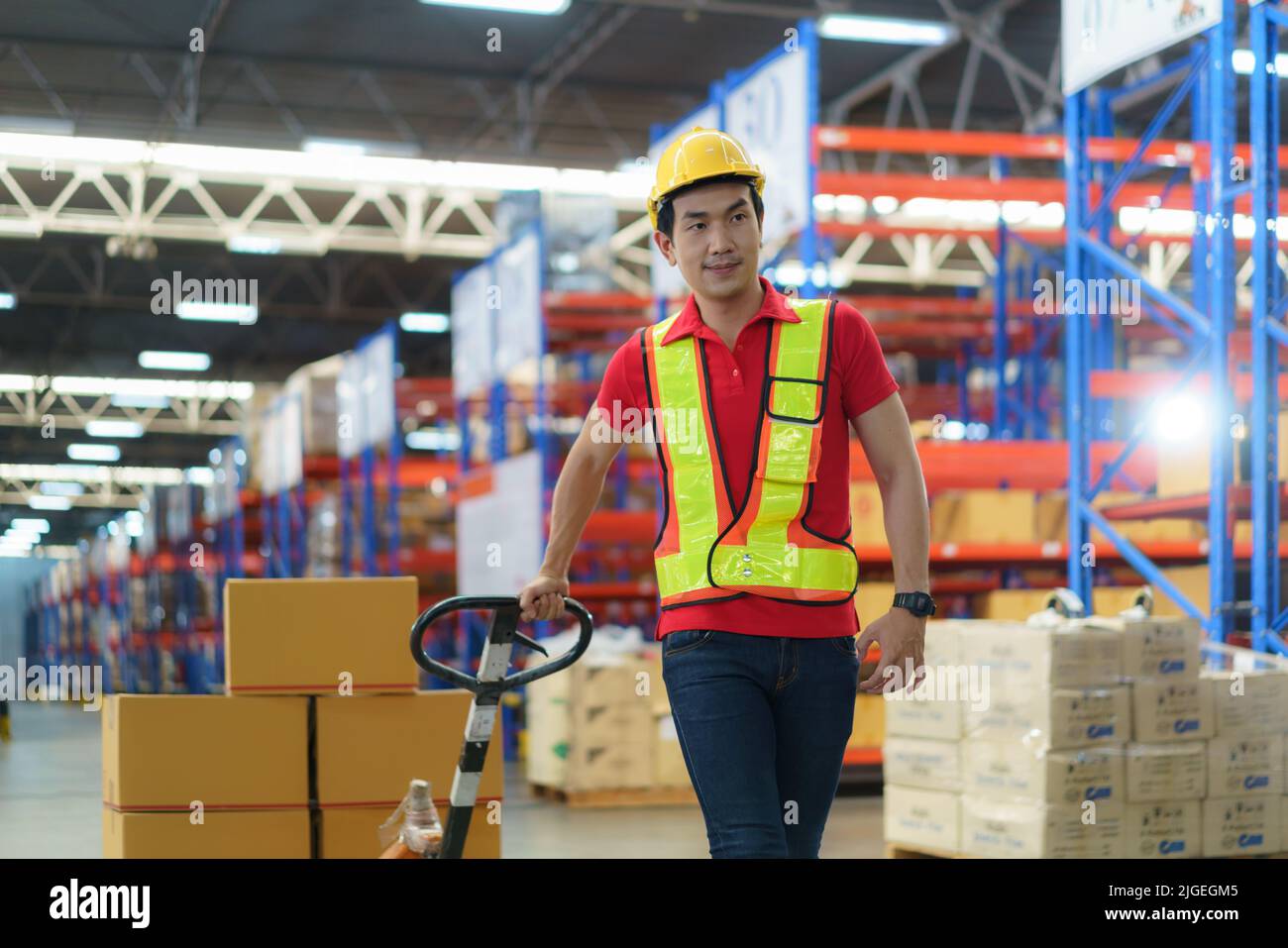 Shipping boxes. Asian man Warehouse worker unloading pallet shipment goods into a truck container, warehouse industry freight, logistics and transport Stock Photo