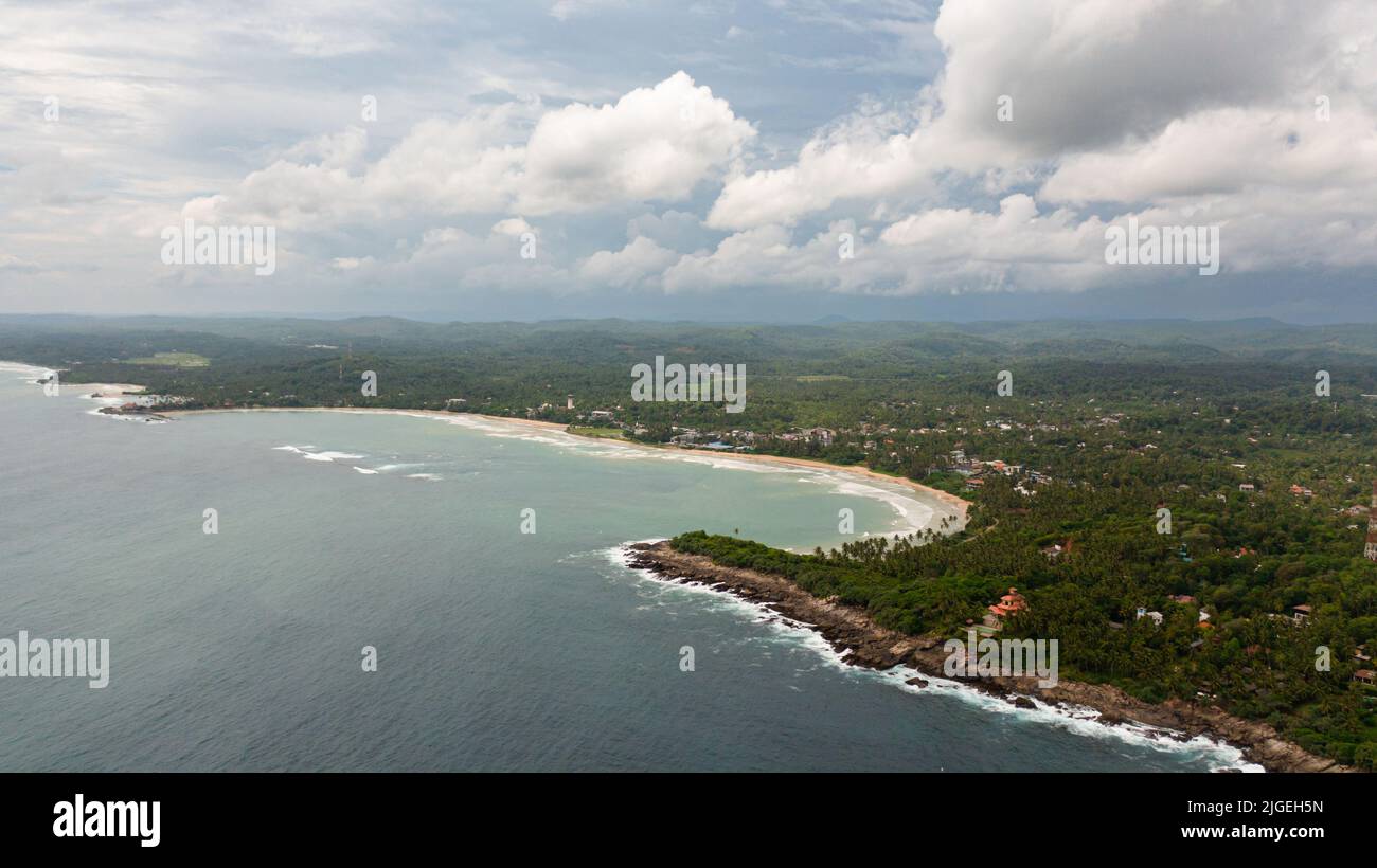 Top view of coast with a beach and hotels among palm trees. Dickwella Beach, Sri Lanka. Stock Photo