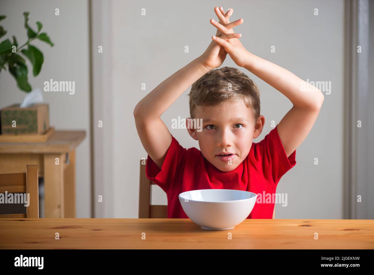Cute boy playing with granola at breakfast. Genuine expressions Stock