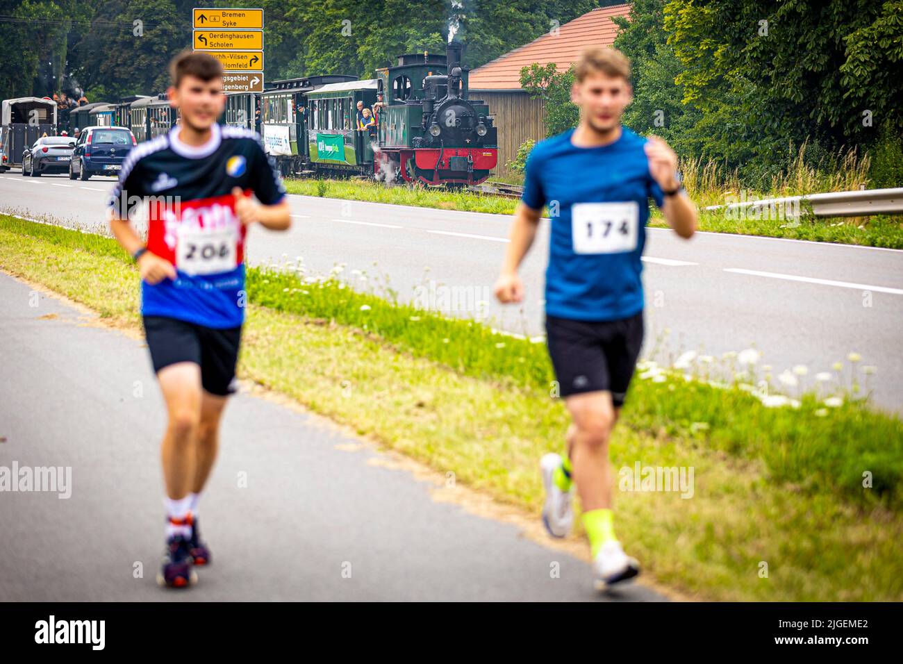 Bruchhausen Vilsen, Germany. 10th July, 2022. Runners take part in the 'Man against Machine' race in the Diepholz district. The running course runs mainly parallel to a running steam train of the museum railroad. Credit: Moritz Frankenberg/dpa/Alamy Live News Stock Photo