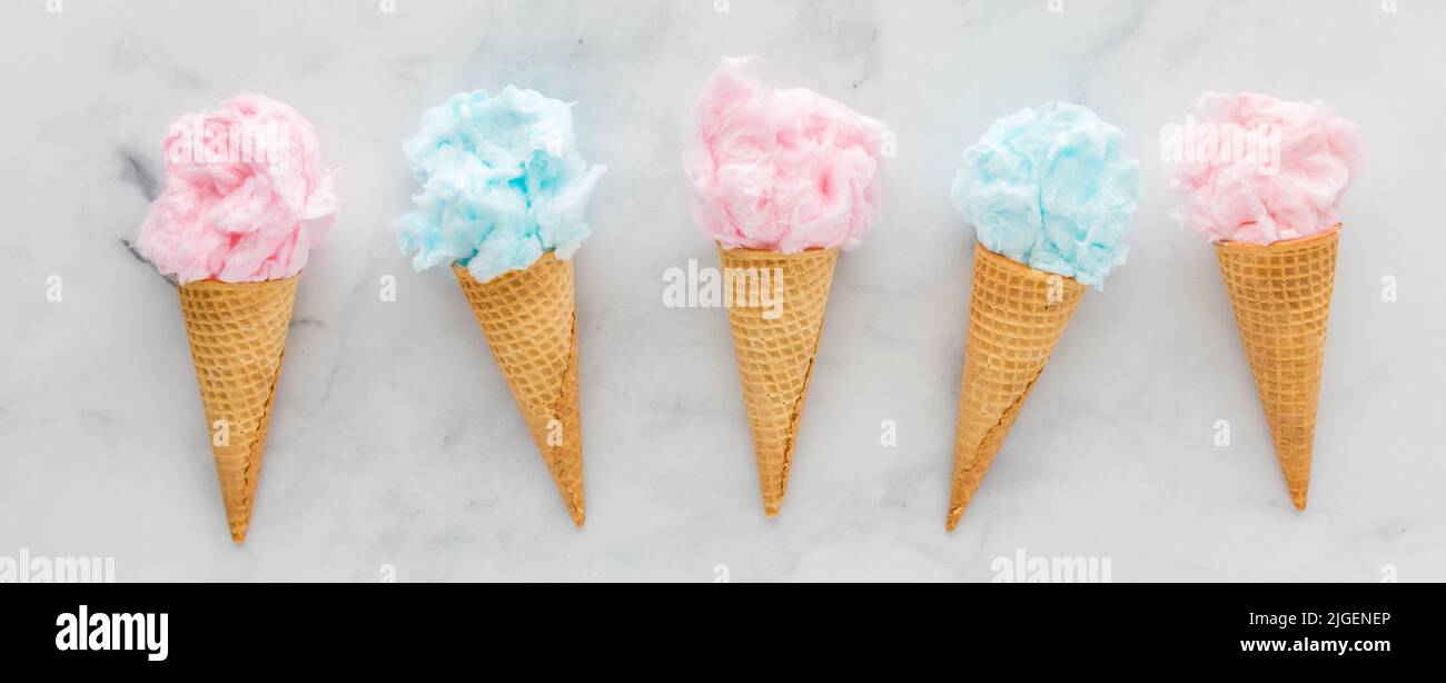 Waffle cones filled with cotton candy, against a light background. Stock Photo