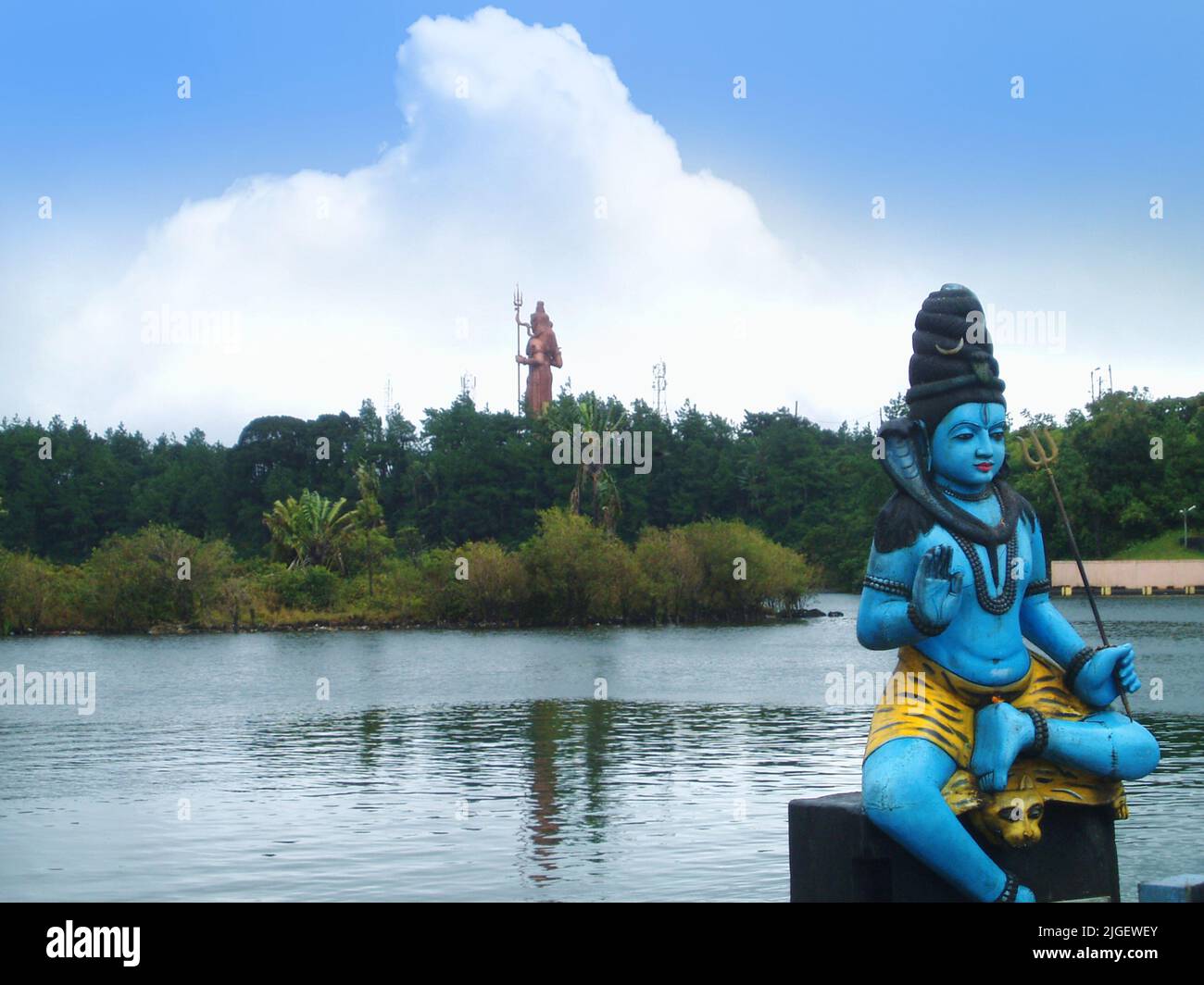 Sculpture of a Hindu God (Shiva) in front of crater lake Grand Bassin in Mauritius. Sculpture of Hindu god Shiva (33 meter tall) at the background Stock Photo
