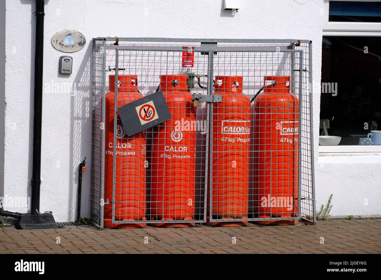 Four large propane gas bottles in protective cage to heat residence. Stock Photo