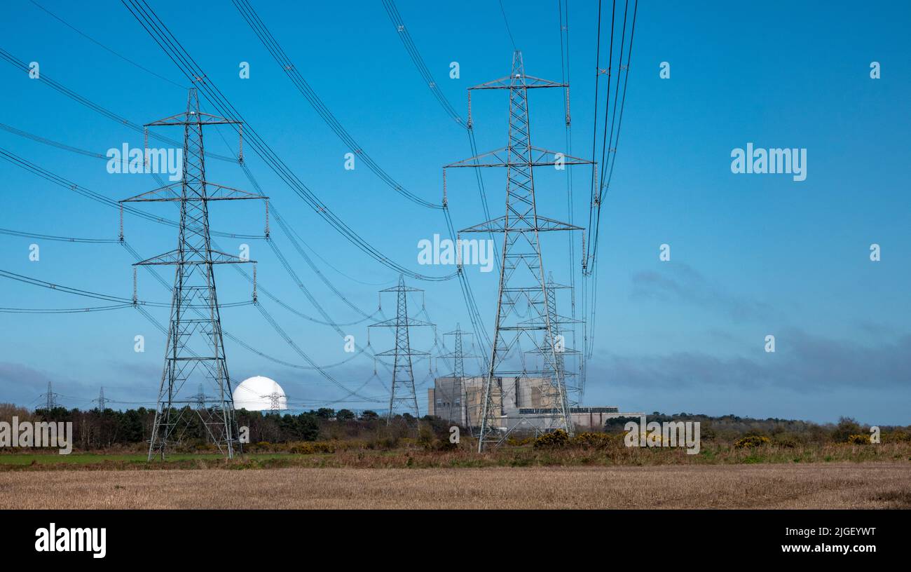 Sizewell Nuclear Power Stations in the far distance with green fields in the foreground with many power lines Stock Photo