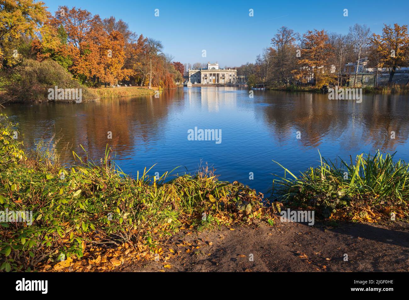 Royal Łazienki Park in city of Warsaw in Poland. Autumn landscape with lake and Palace on the Isle at the far end. Stock Photo