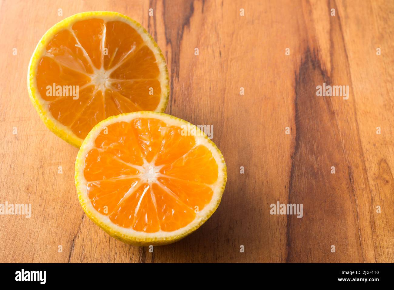 sweet orange fruit slices, isolated on a wooden surface, taken in shallow depth of field with copy space Stock Photo