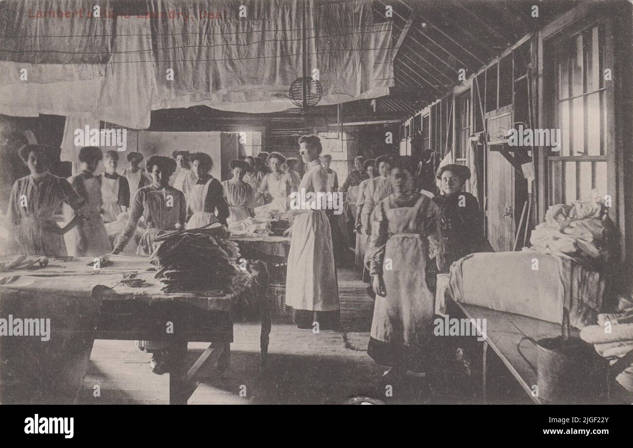 Lambert's Hand Laundry, Deal, Kent, 1913: photographic postcard showing the women workers in the laundry, with sheets hanging from the rafters Stock Photo