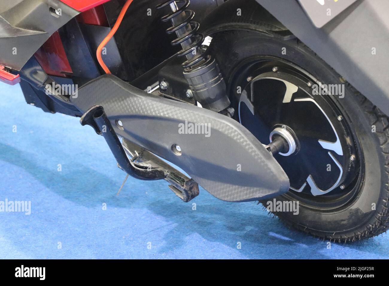 Electric scooter rear wheel with brushless dc motor connected along with a view of suspension spring Stock Photo