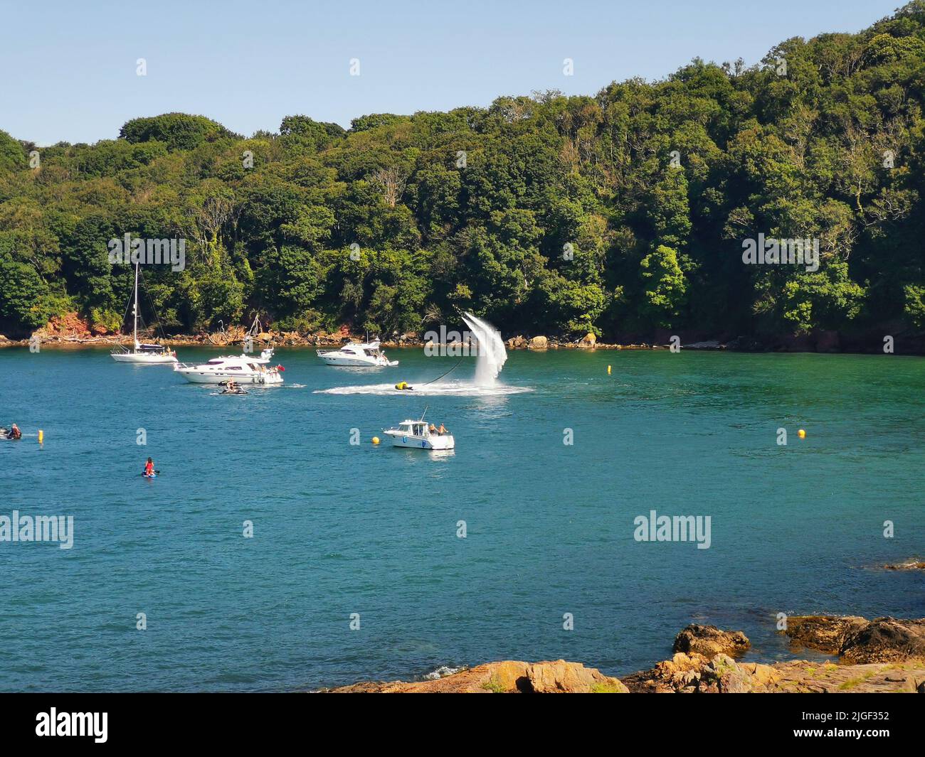 Paignton, UK. Sunday 10 July 2022. Man riding an aqua jet near Elberry Cove in Devon on a hot summer's day. Credit: Thomas Faull/Alamy Live News Stock Photo