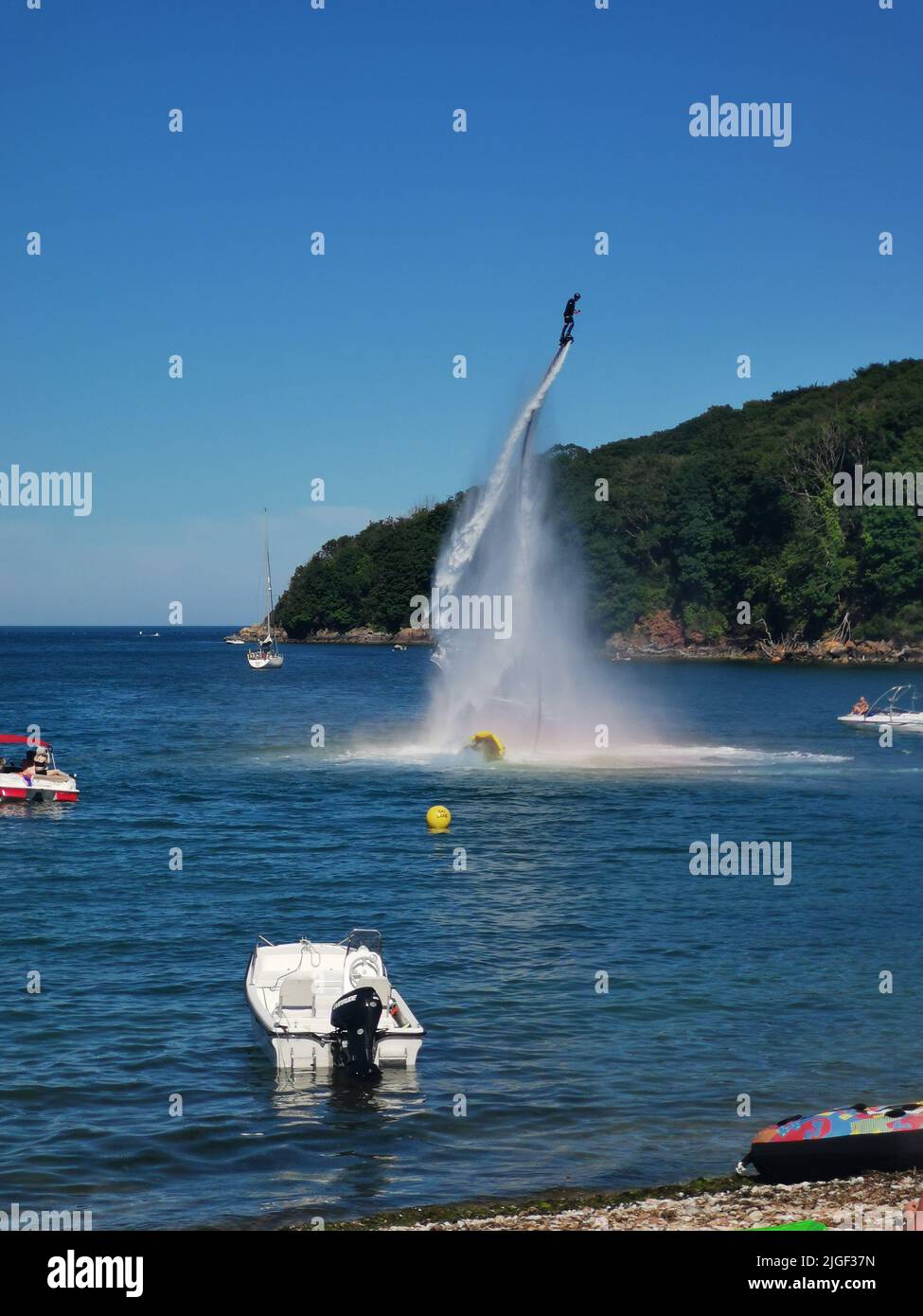 Paignton, UK. Sunday 10 July 2022. Man riding an aqua jet near Elberry Cove in Devon on a hot summer's day. Credit: Thomas Faull/Alamy Live News Stock Photo