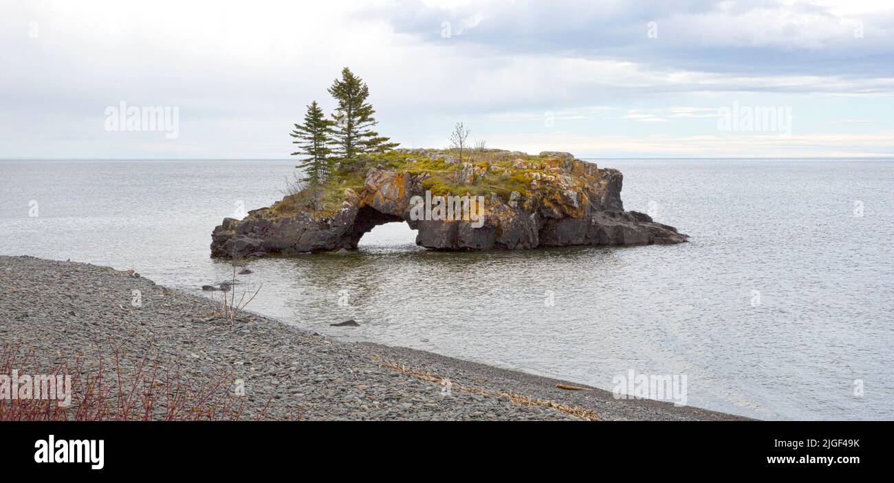 Island and landform known as Hollow Rock in Lake Superior near Grand Portage, Minnesota. Twice a year, for about a week in November and a week in Janu Stock Photo