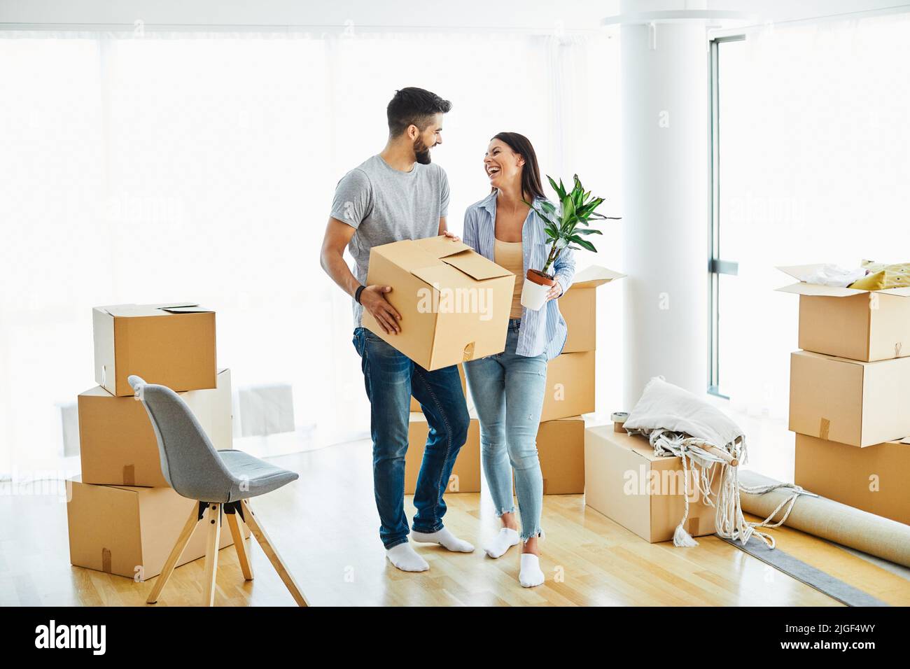 woman couple man box home house moving happy apartment together romantic relocation new property Stock Photo