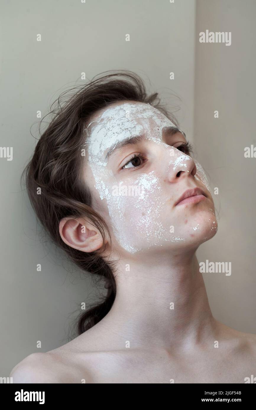 Teenage boy wearing clay face mask. Stock Photo