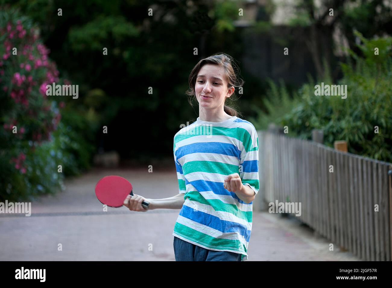 13 year-old boy playing table tennis outside Stock Photo