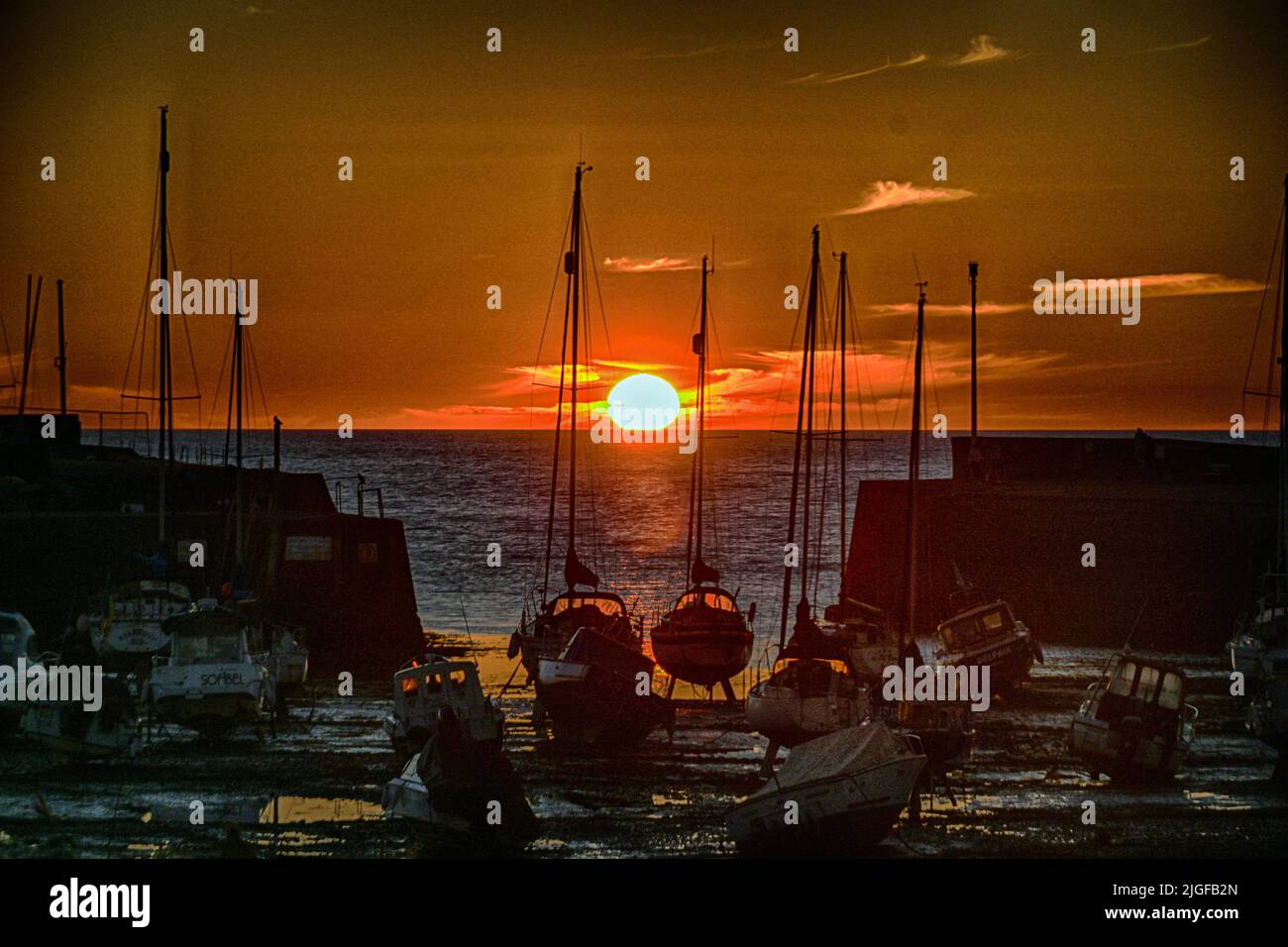 Suns sets in front of the harbor ABERAERON only happens one day in the year  when it is ded center. Stock Photo