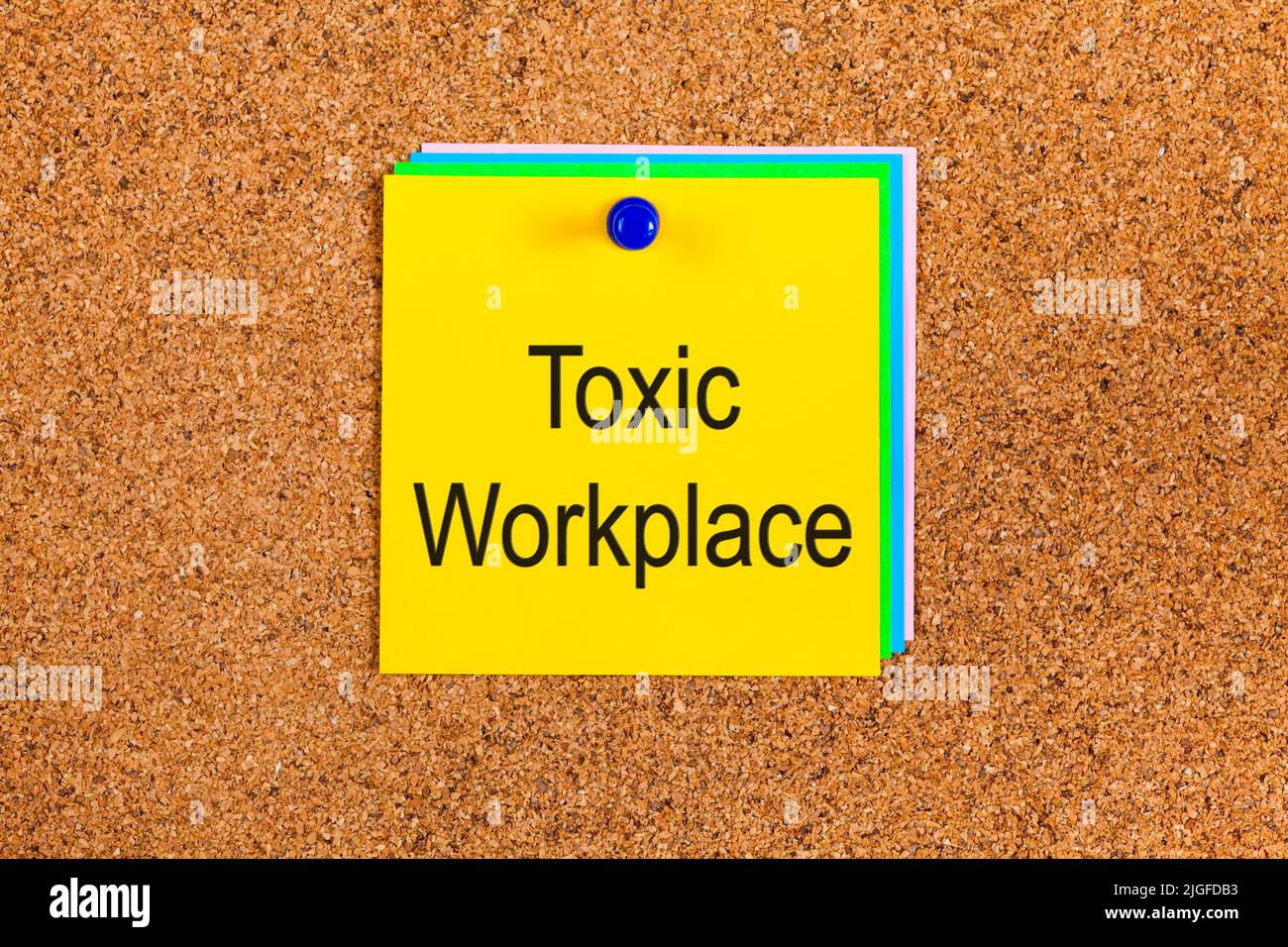 Yellow note with words Toxic Workplace on a corkboard Stock Photo