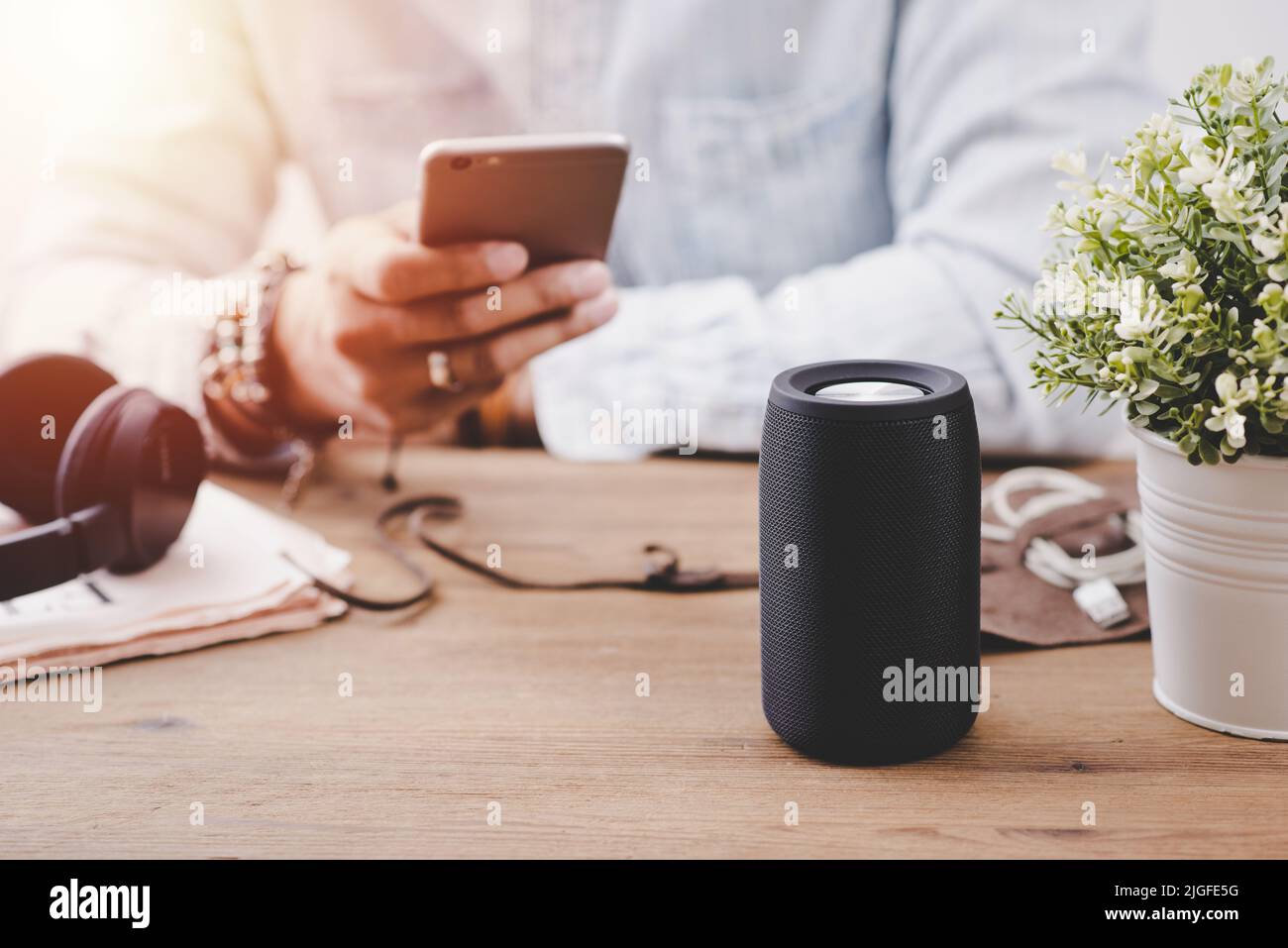 The man streams music from smartphone to bluetooth speaker. Stock Photo