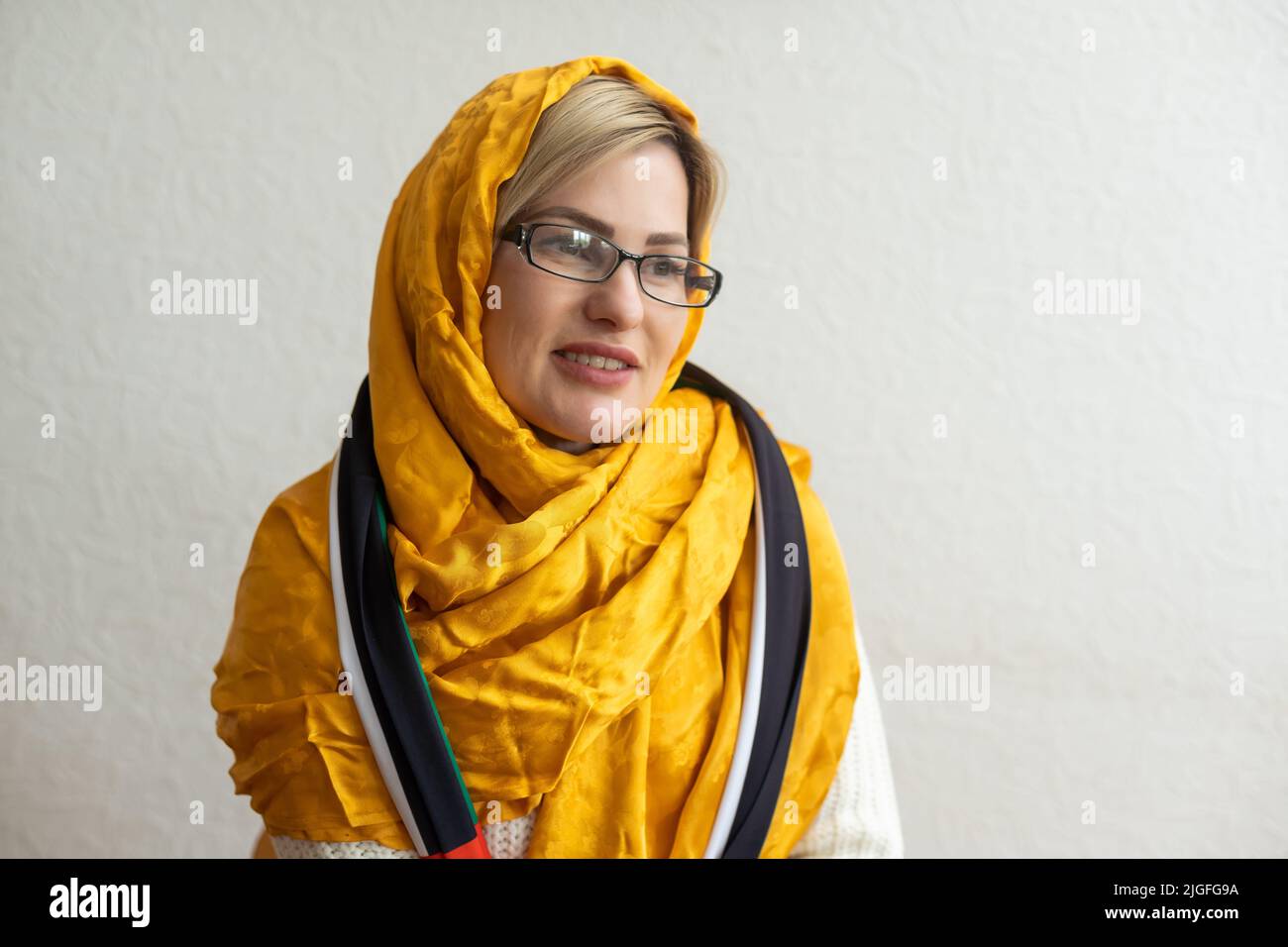 Proud confident Arab emirati woman standing celebrating Uae National day wearing a scarf in arabic Stock Photo