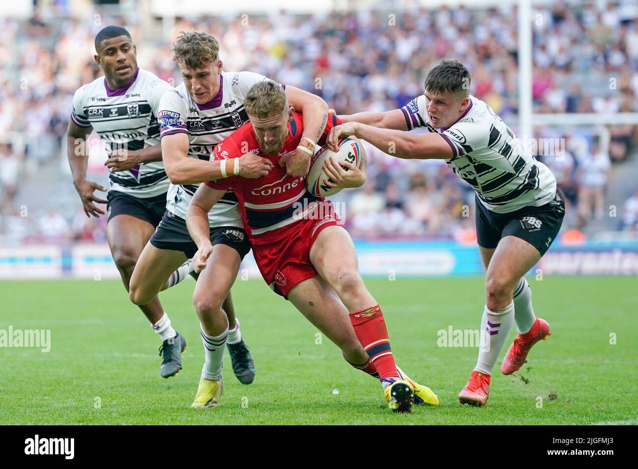 Hull KR 21 Rowan Milnes carries Hull FC players with him as he drives