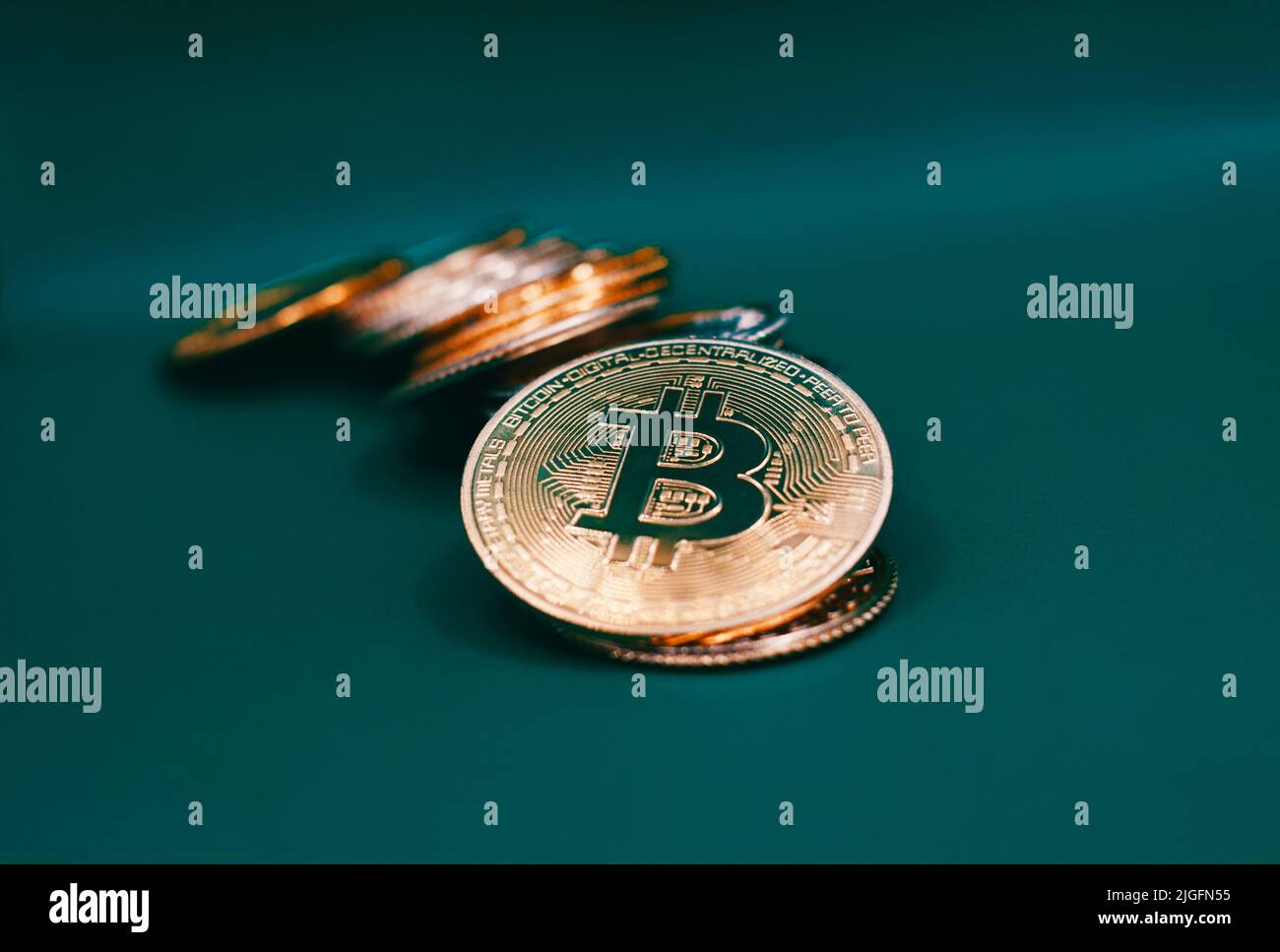 Stack of bitcoins on a green table . Stock Photo