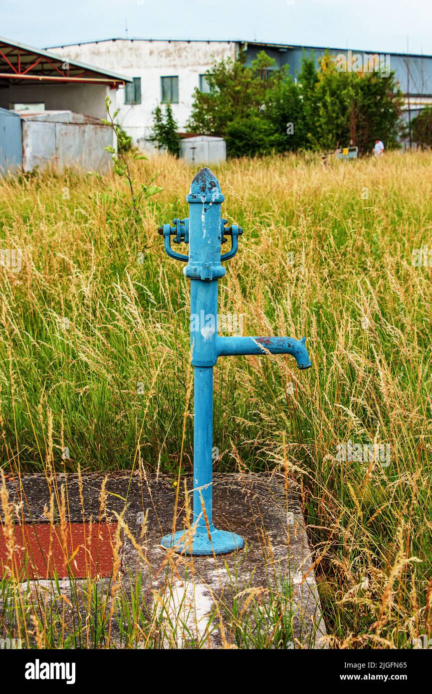 Retro borehole pump on a sunny day, old manual water pump (lever pump). Old cast iron water pump