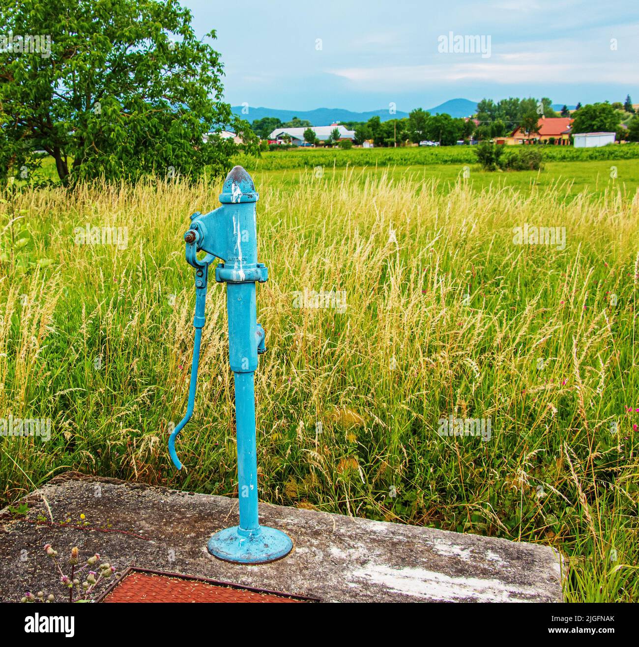 Retro borehole pump on a sunny day, old manual water pump (lever pump). Old cast iron water pump