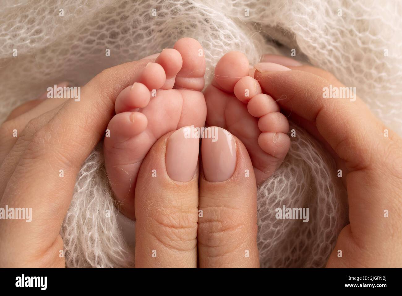 A new born baby's feet next to her mothers hand shows just how tiny babies  really are Stock Photo - Alamy