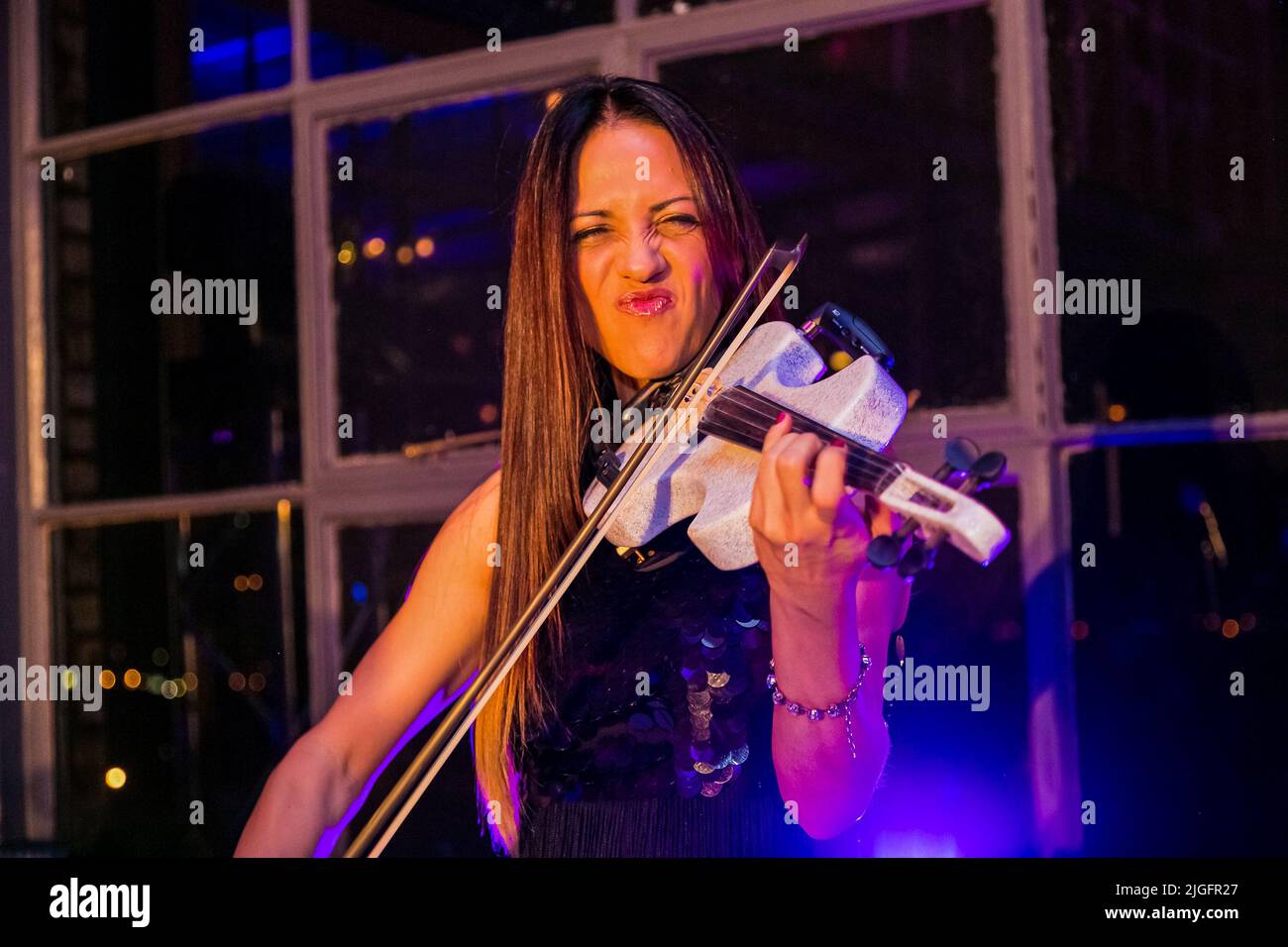 A female musician playing the violin at party event Stock Photo