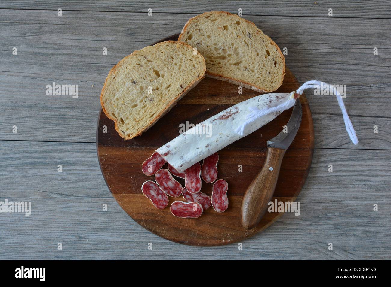 Very spicy Spanish pork sausage with white mold, sliced on dark wooden