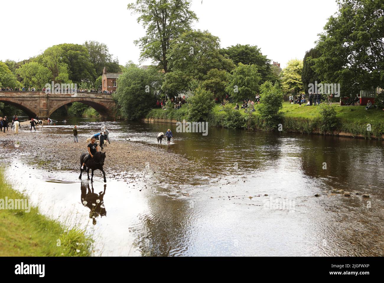 A teenage girl riding her horse in the River Eden, Appleby Horse Fair, Appleby in Westmorland, Cumbria Stock Photo