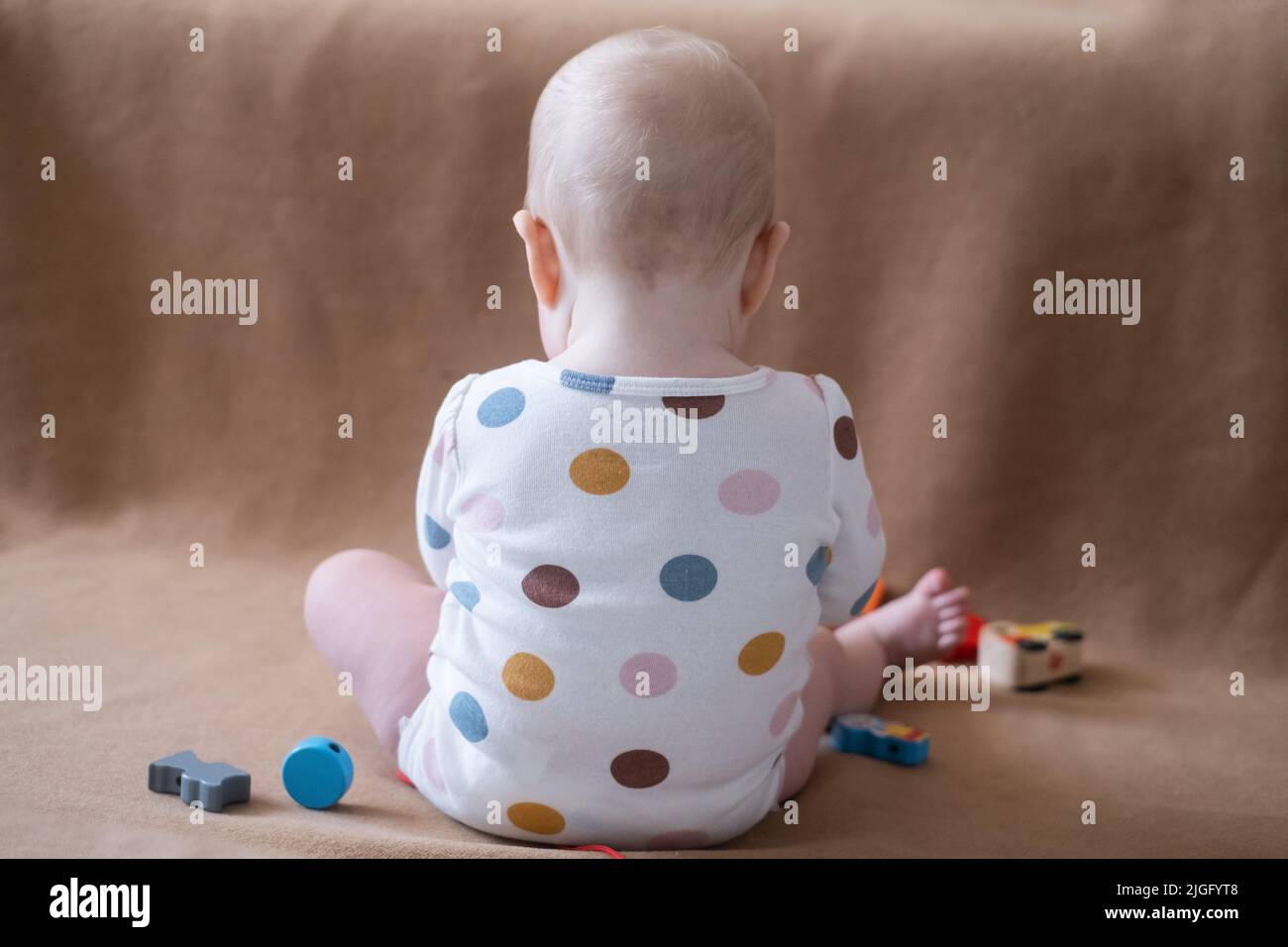childhood and people concept. 8 month old caucasian baby girl playing with toy at home Stock Photo
