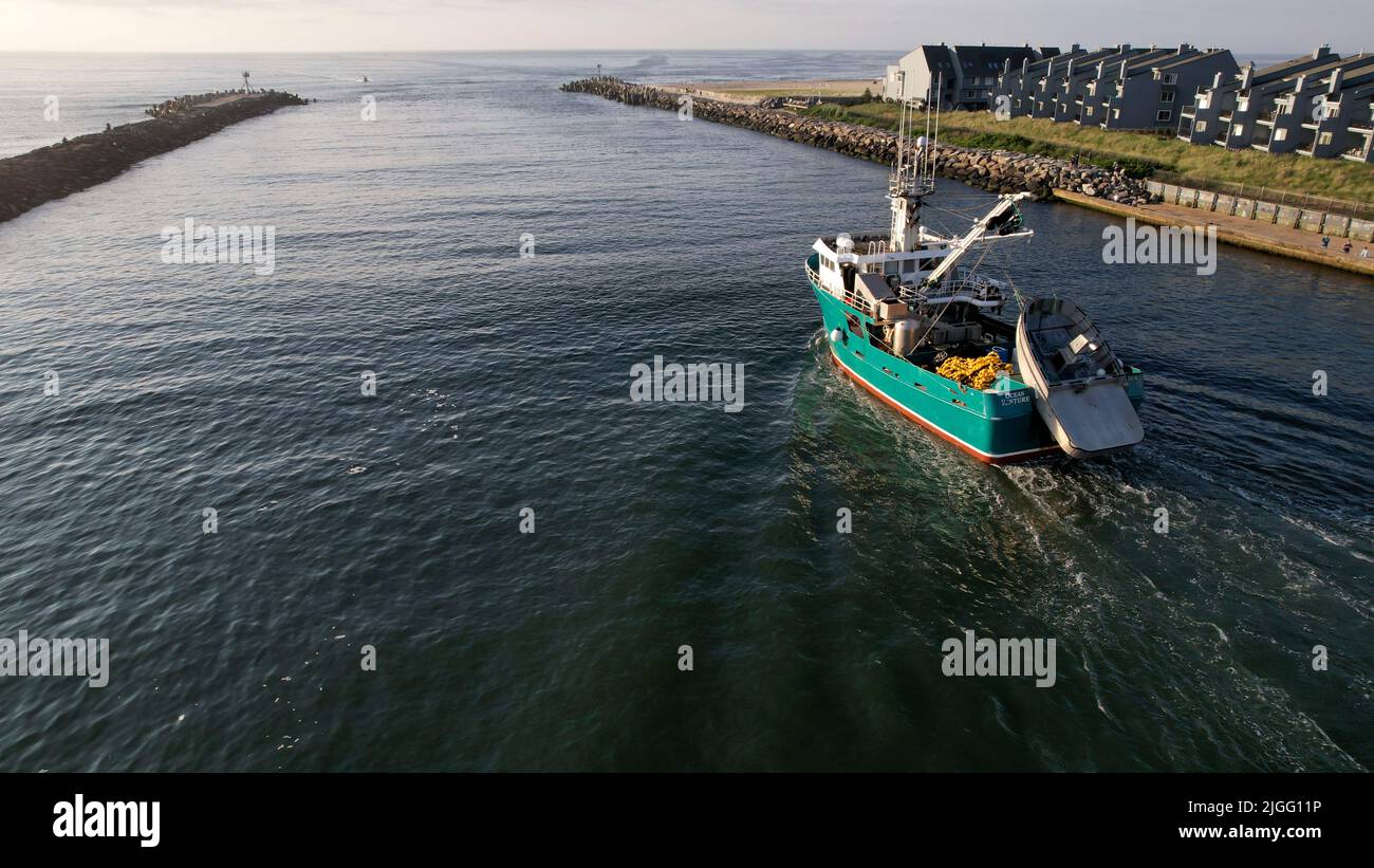 Aerial view of boat along the Manasquan Inlet heading to the Atlantic Ocean In Manasquan, NJ Stock Photo