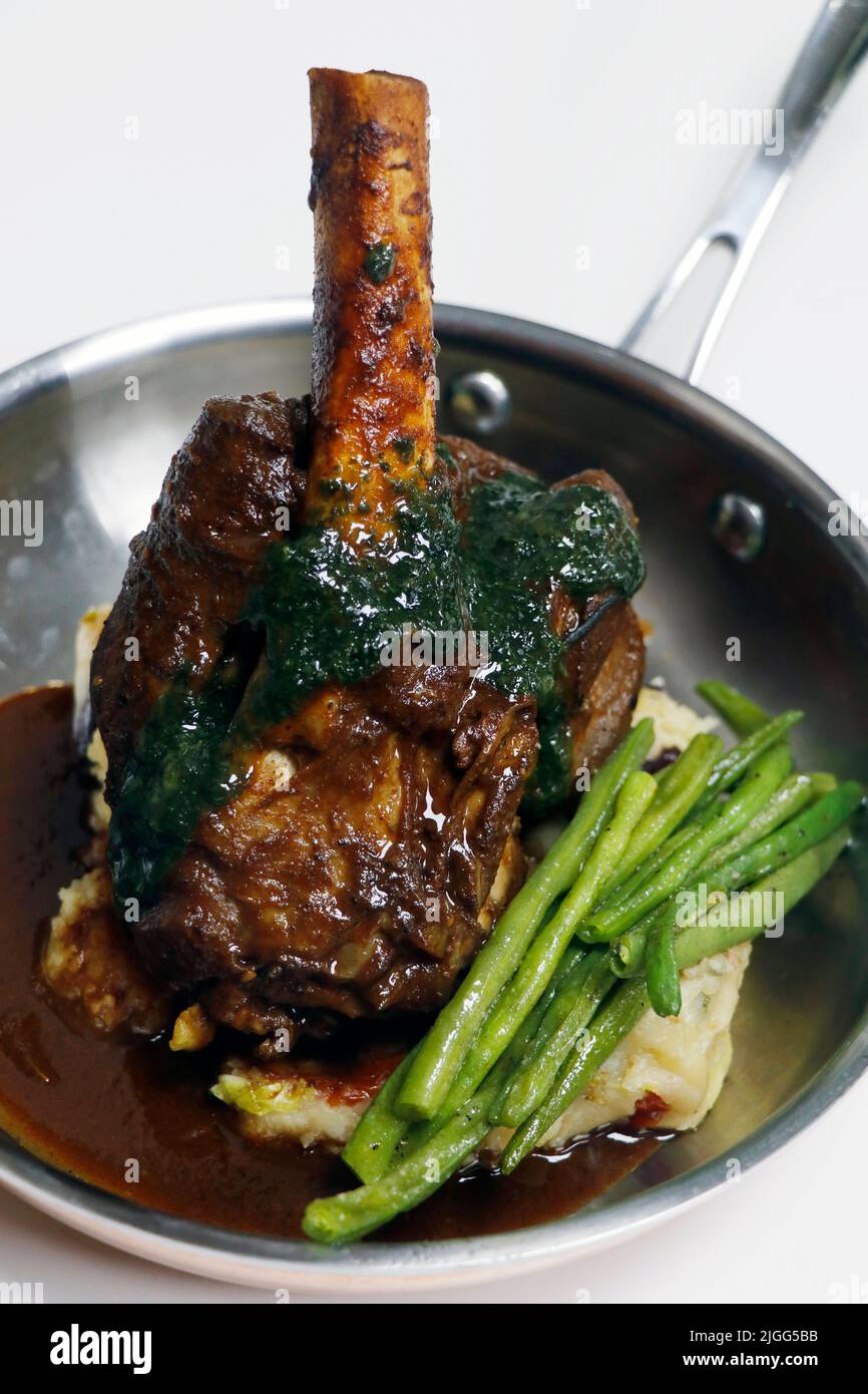 slow cooked lamb hind shank with potato and green beans Stock Photo Alamy