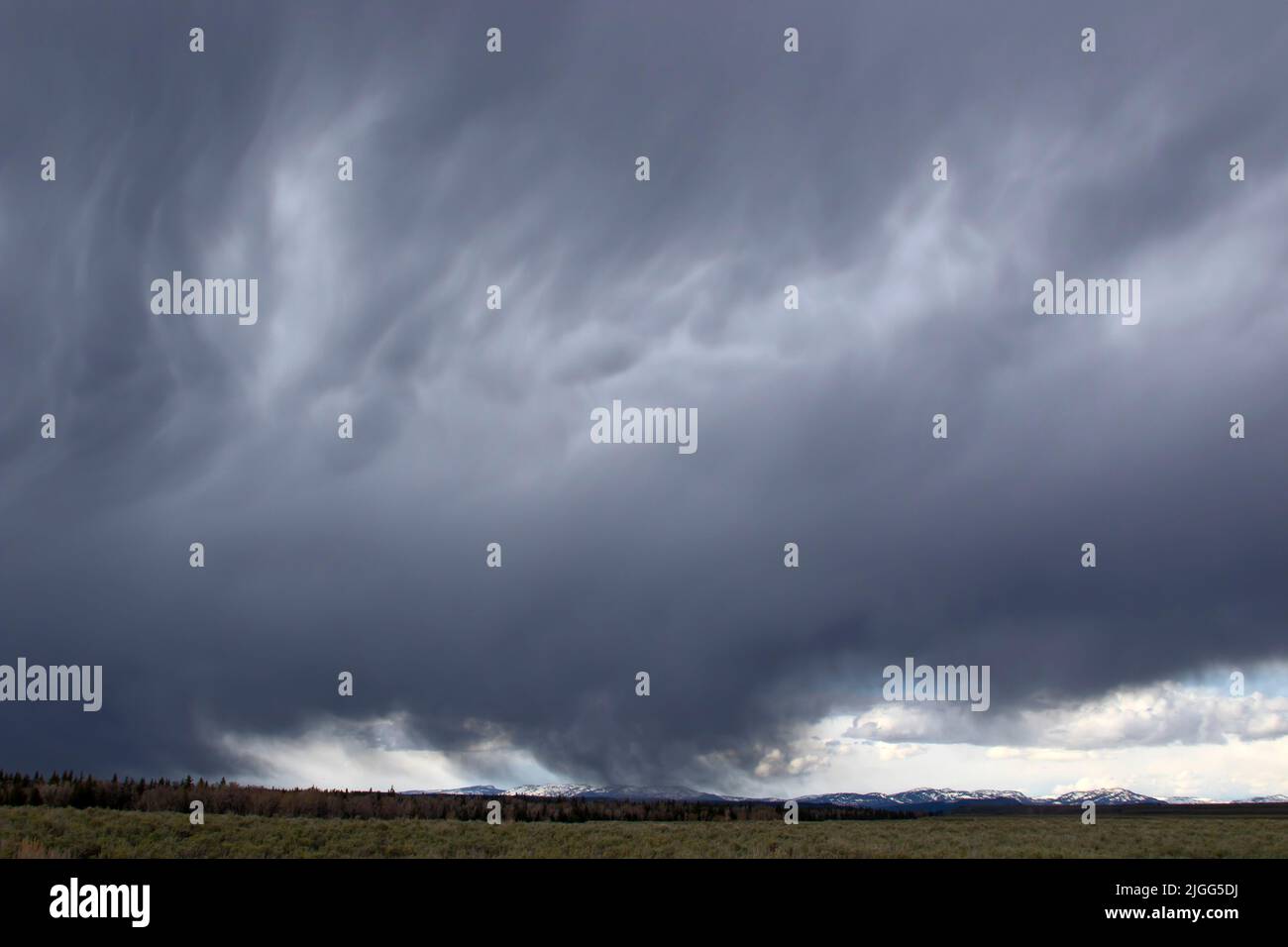 A fast-moving, late-May weather front moves across a sagebrush flat on Wyoming's Grand Teton NP, USA. Stock Photo