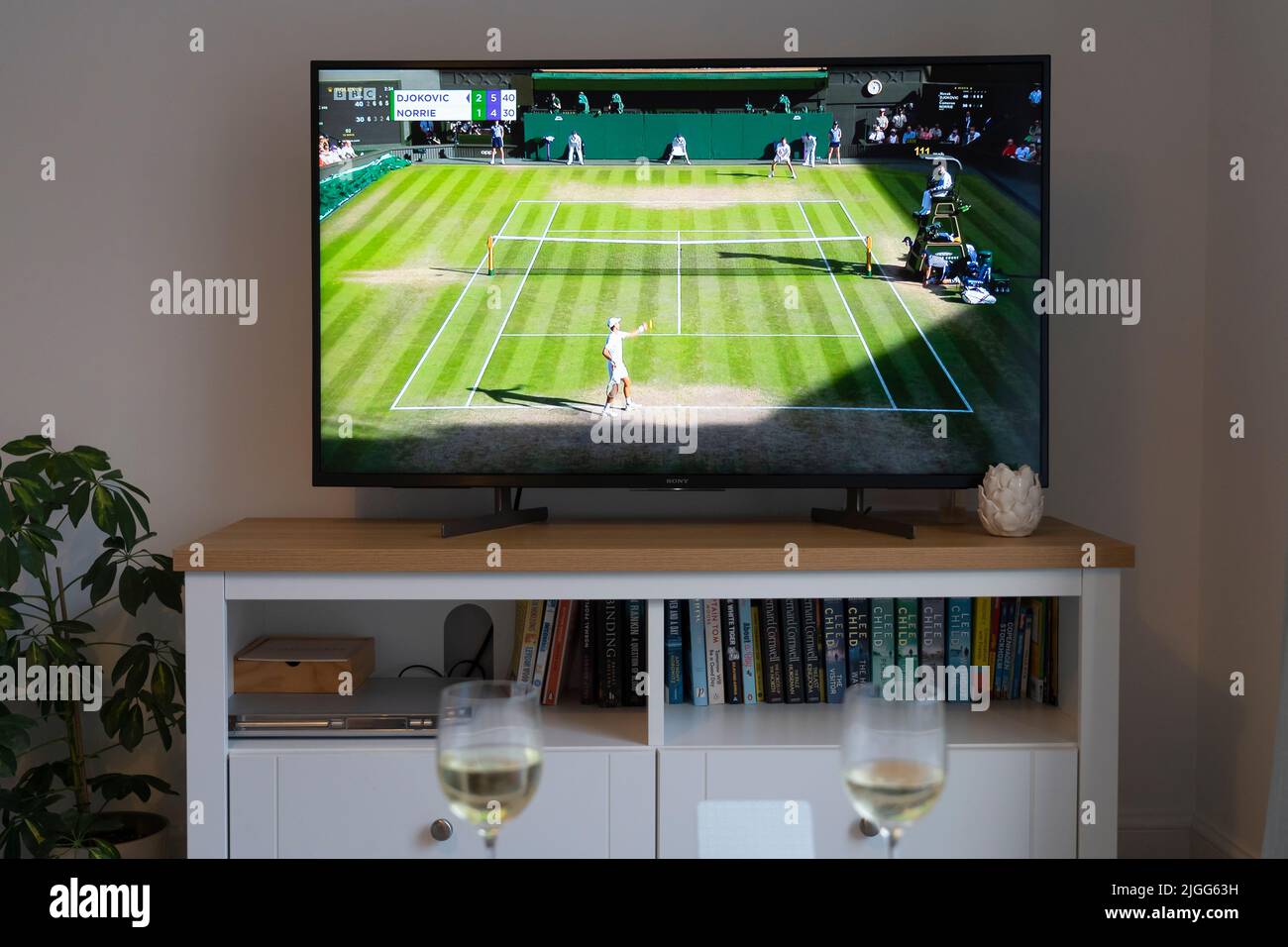 Novak Djokovic serves against Cameron Norrie at Wimbledon 2022 men's tennis singles semi final on 8th July 2022 on a tv in a lounge. UK Stock Photo