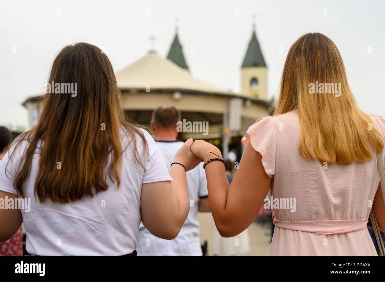 Two girls holding hands in prayer during Mladifest 2021 – the youth festival – in Medjugorje. Stock Photo