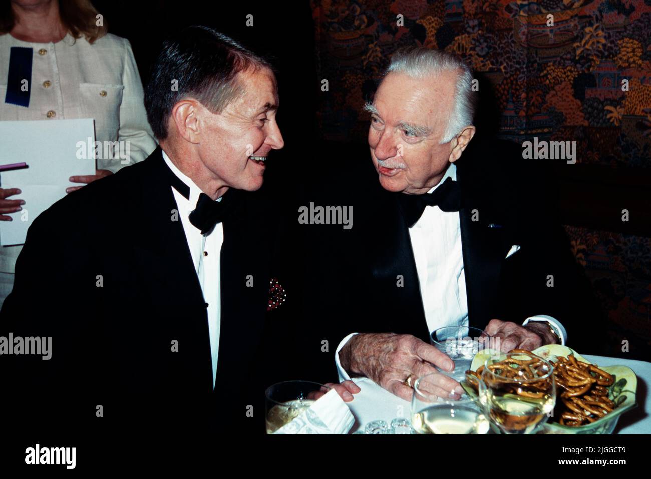 Legendary television news anchor Walter Cronkite, right, chats with CBS White House correspondent Bill Plante, left, during the American News Women’s Club annual Roast and Toast Dinner at the Four Seasons Hotel, May 13, 1997 in Washington, D.C. Cronkite was presented with the Excellence in Journalism Award during the event. Stock Photo