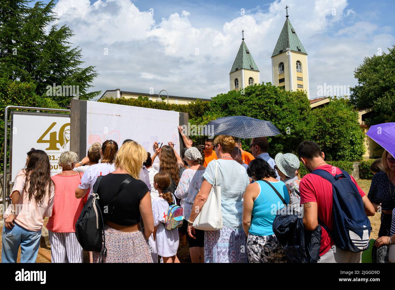 Young people writing their prayers onto a long roll of sheet during Mladifest 2021 – the youth festival – in Medjugorje. Stock Photo
