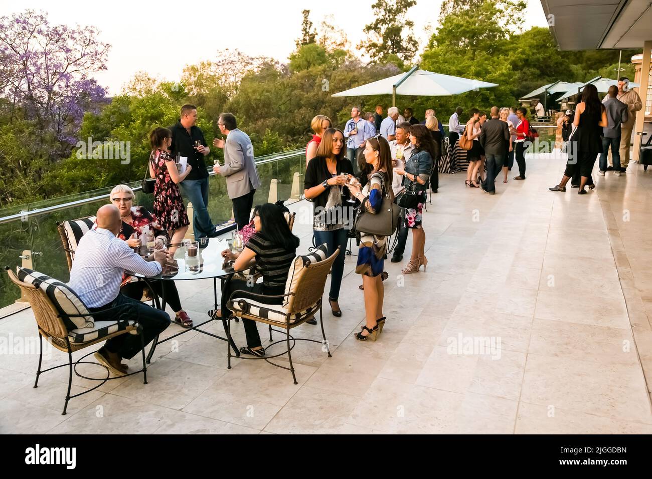 Diverse people socializing at an outdoor cocktail party in Johannesburg, South Africa Stock Photo