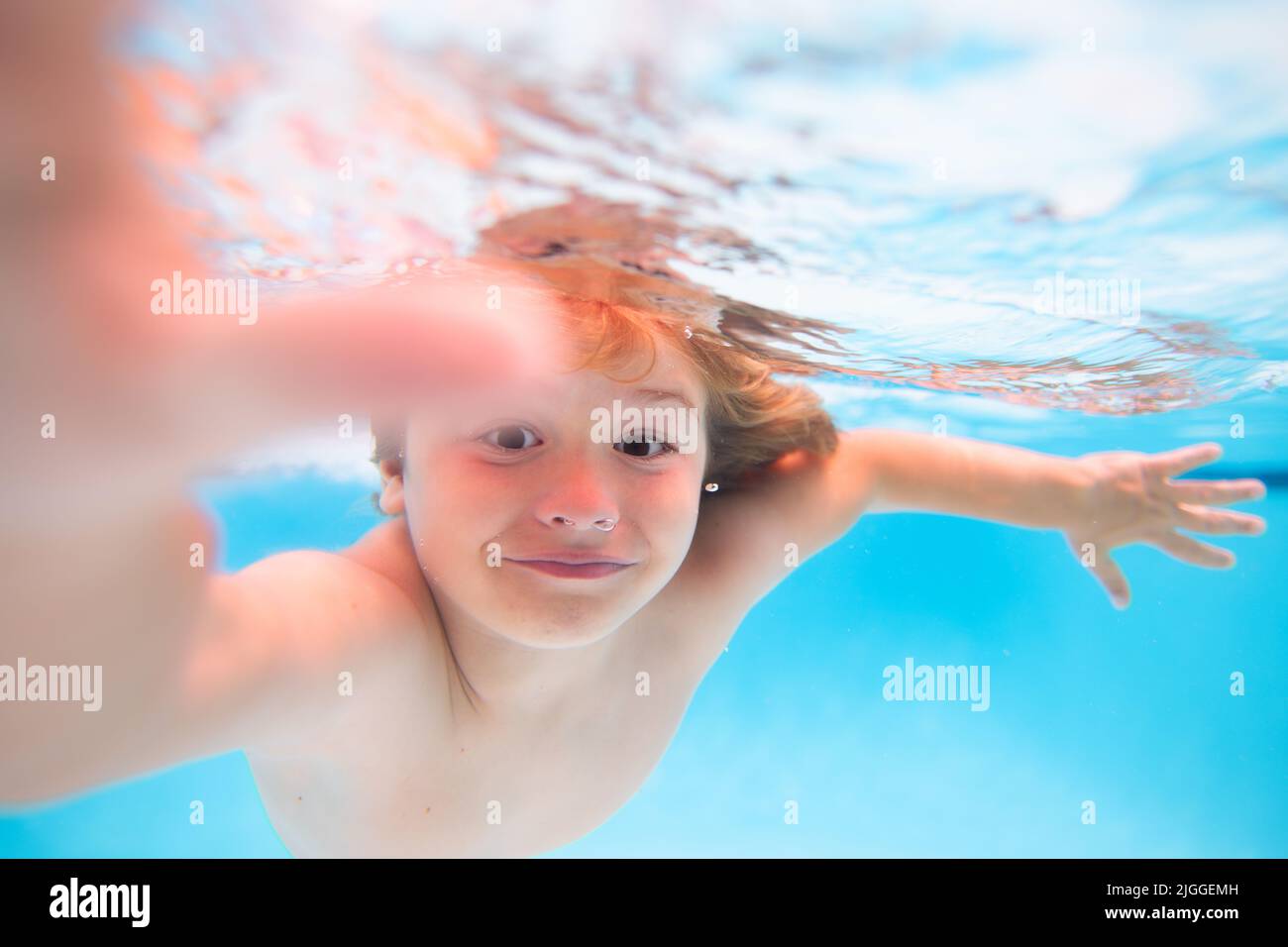 Underwater boy in the swimming pool. Cute kid boy swimming in pool