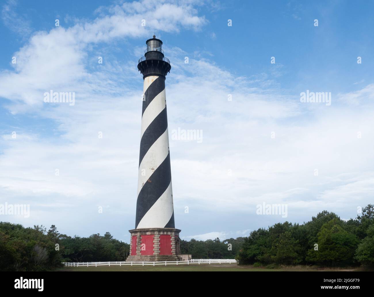 Cape Hatteras light station with black and white spiral stripes, sitting on a red pedestal. Located in Cape Hatteras National Seashore, North Carolina Stock Photo