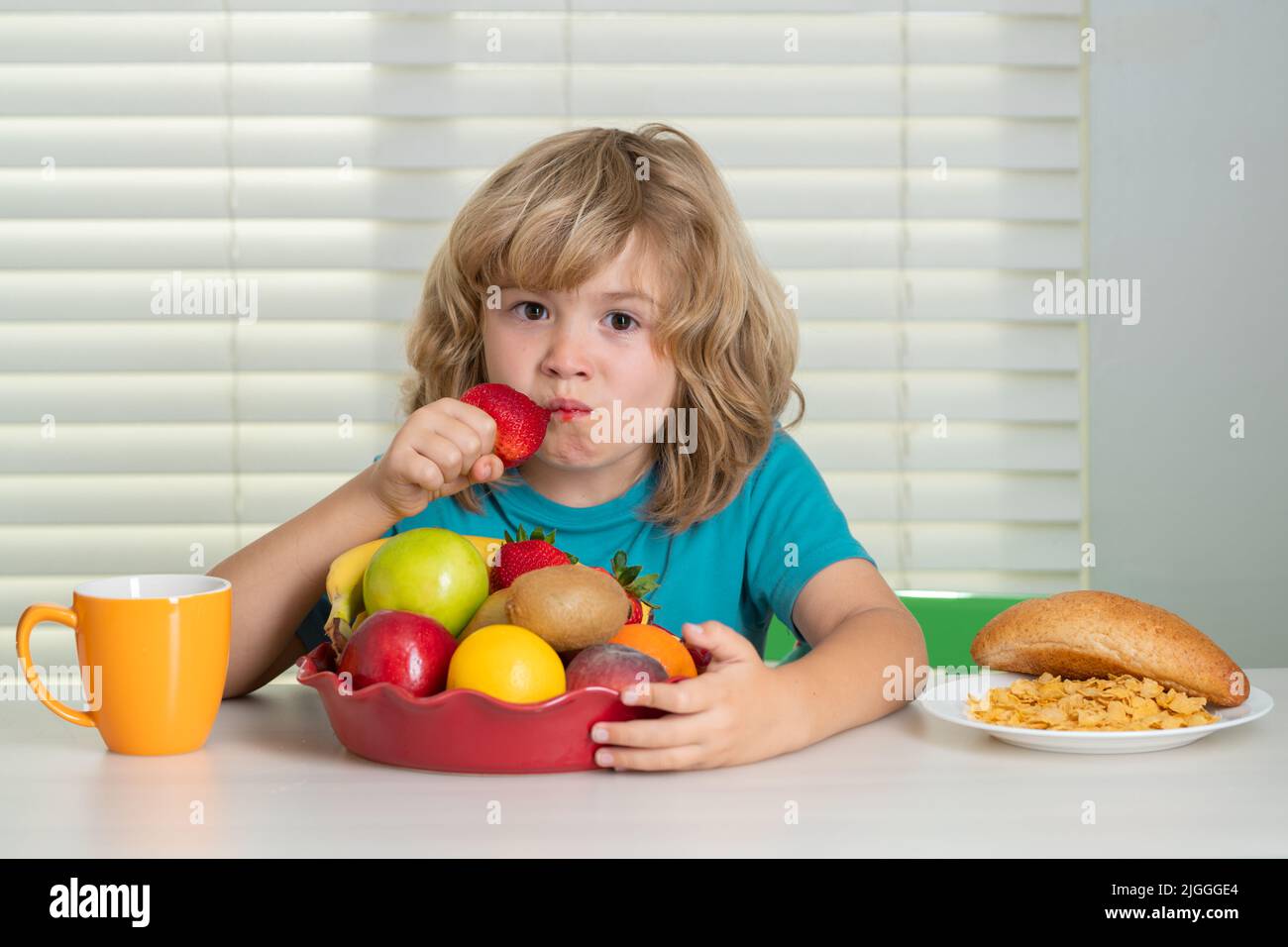 Child eats strawberry, organic fruits. Kid preteen boy 7, 8, 9 years