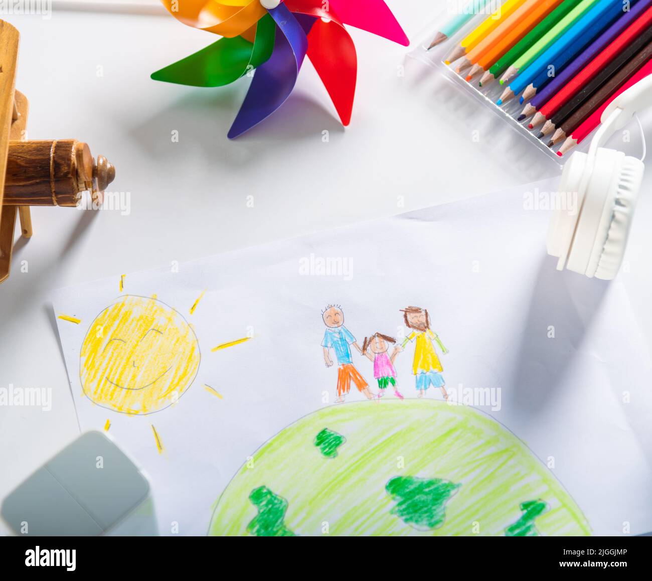 Child colorful drawing family standing hold hands on planet earth on white paper, Kid preschooler draw picture with pencil on table, Earth day concept Stock Photo