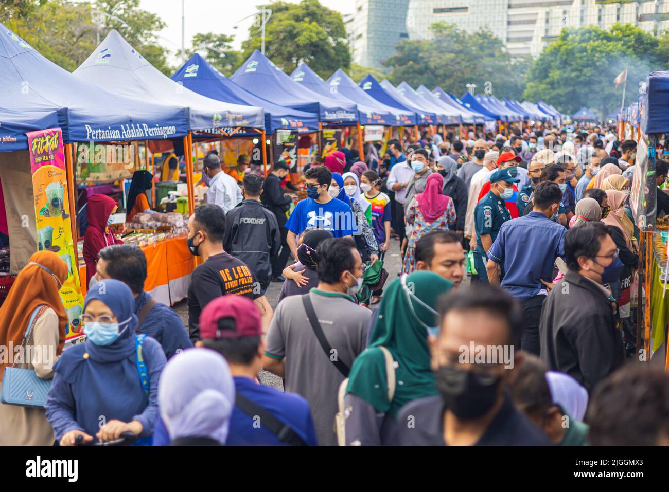 Kuala Lumpur, Malaysia - June 21, 2022: Fresh market on the street. Vegetable, Fruits and fresh chicken are sold on small stands. very many people pus Stock Photo