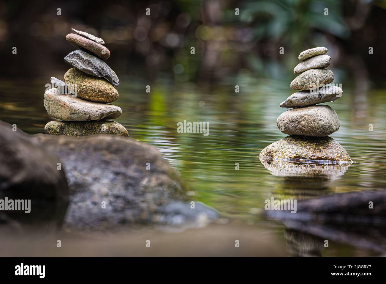 Two stone towers or cairns created by visiting tourists on a pristine freshwater creek at Cape Tribulation in Far North Queensland in Australia. Stock Photo