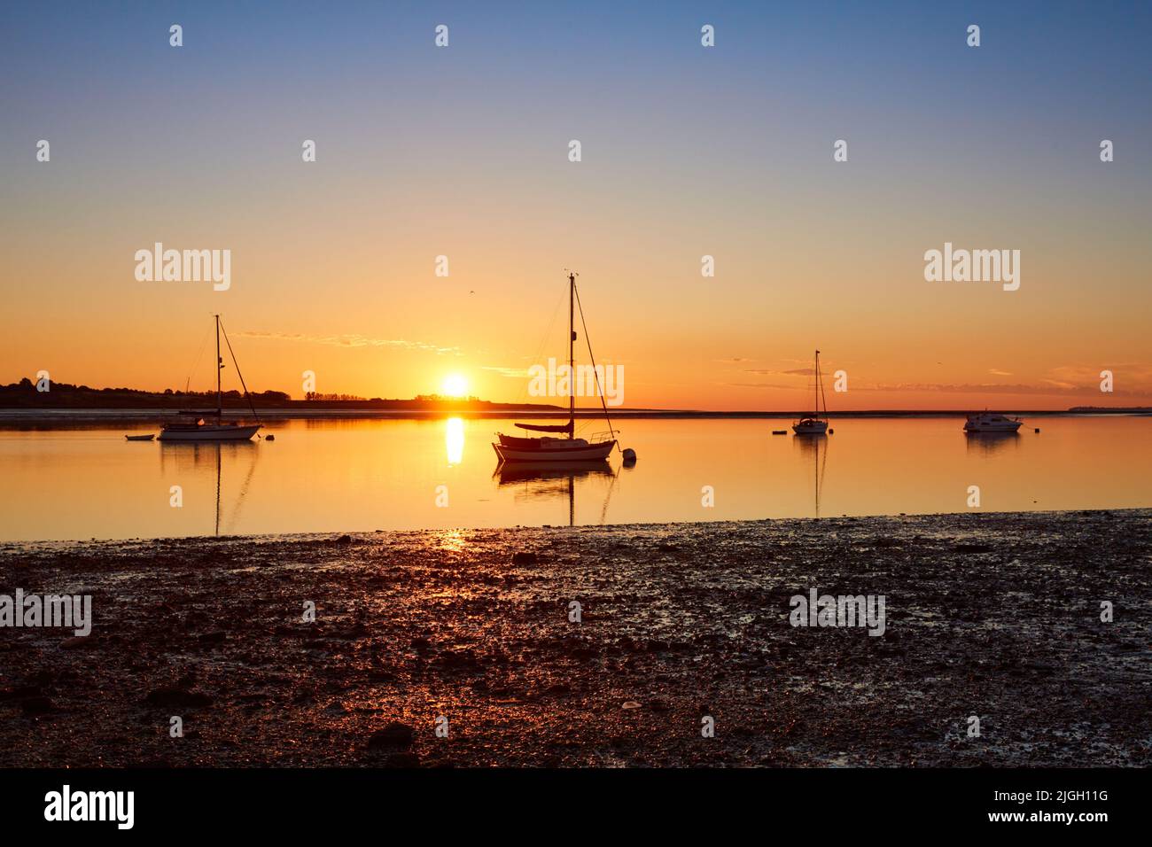 Swale Estuary, Kent, UK. 11th July 2022: UK Weather. A bright clear sunrise over Yachts  moored in the Swale Estuary near Oare in Kent as a week of hot temperatures is predicted possibly rising to the mid 30s. Credit: Alan Payton/Alamy Live News. Stock Photo