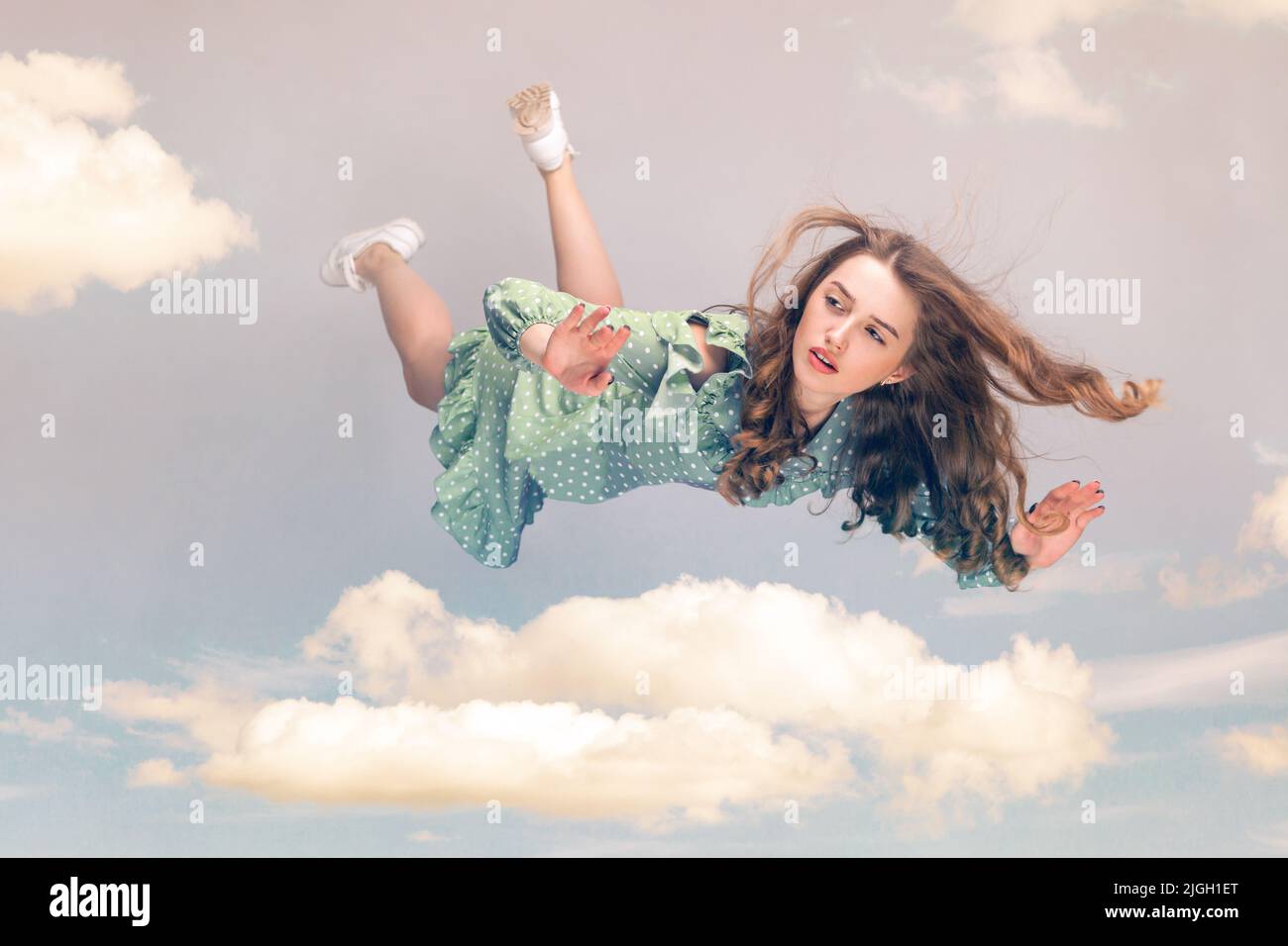Beautiful girl levitating in midair, falling down and her hair messed