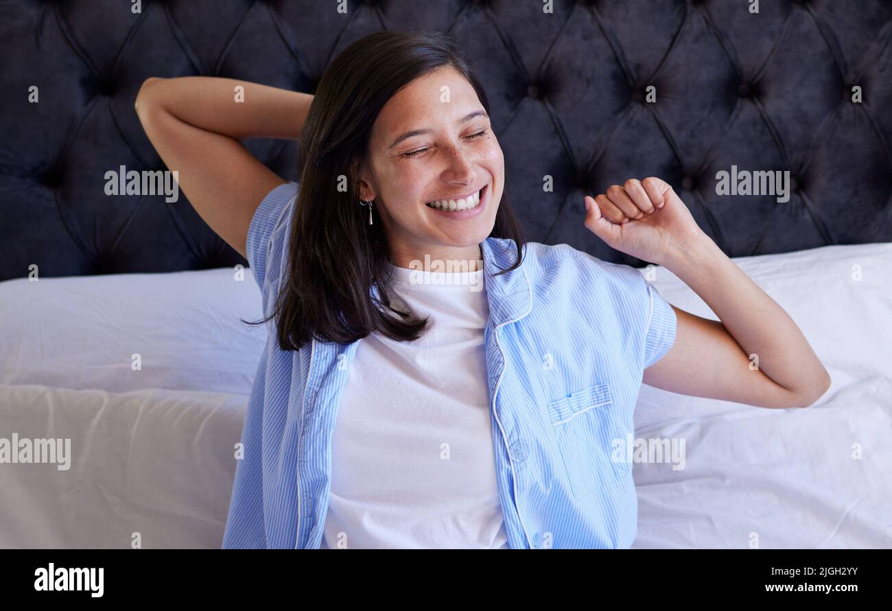 Time to make those dreams a reality. young woman waking up from her sleep in bed at home. Stock Photo