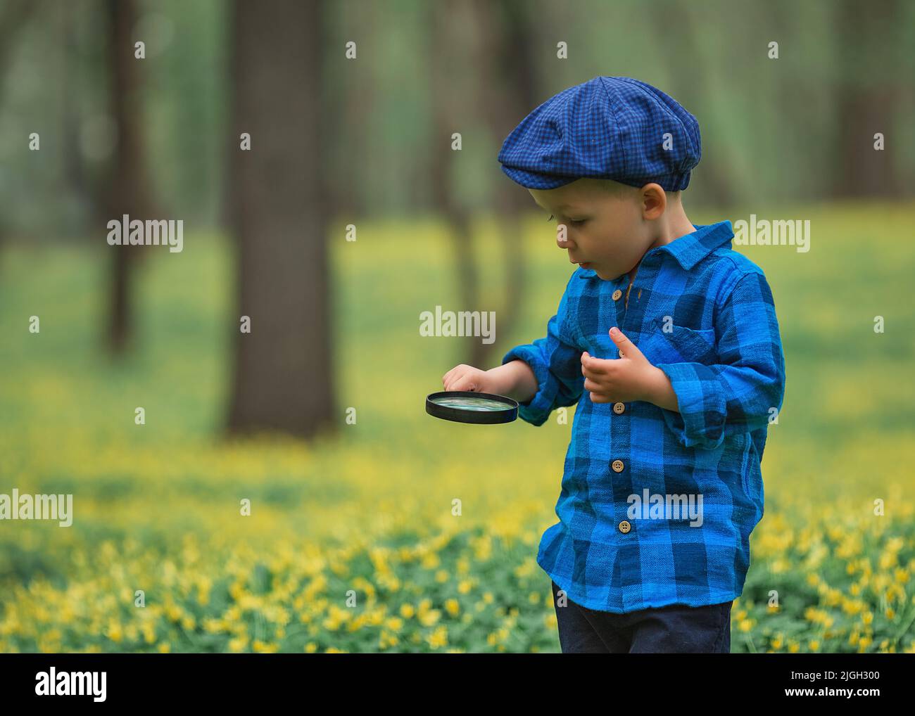 Happy little happy child boy, exploring nature with magnifying glass ...