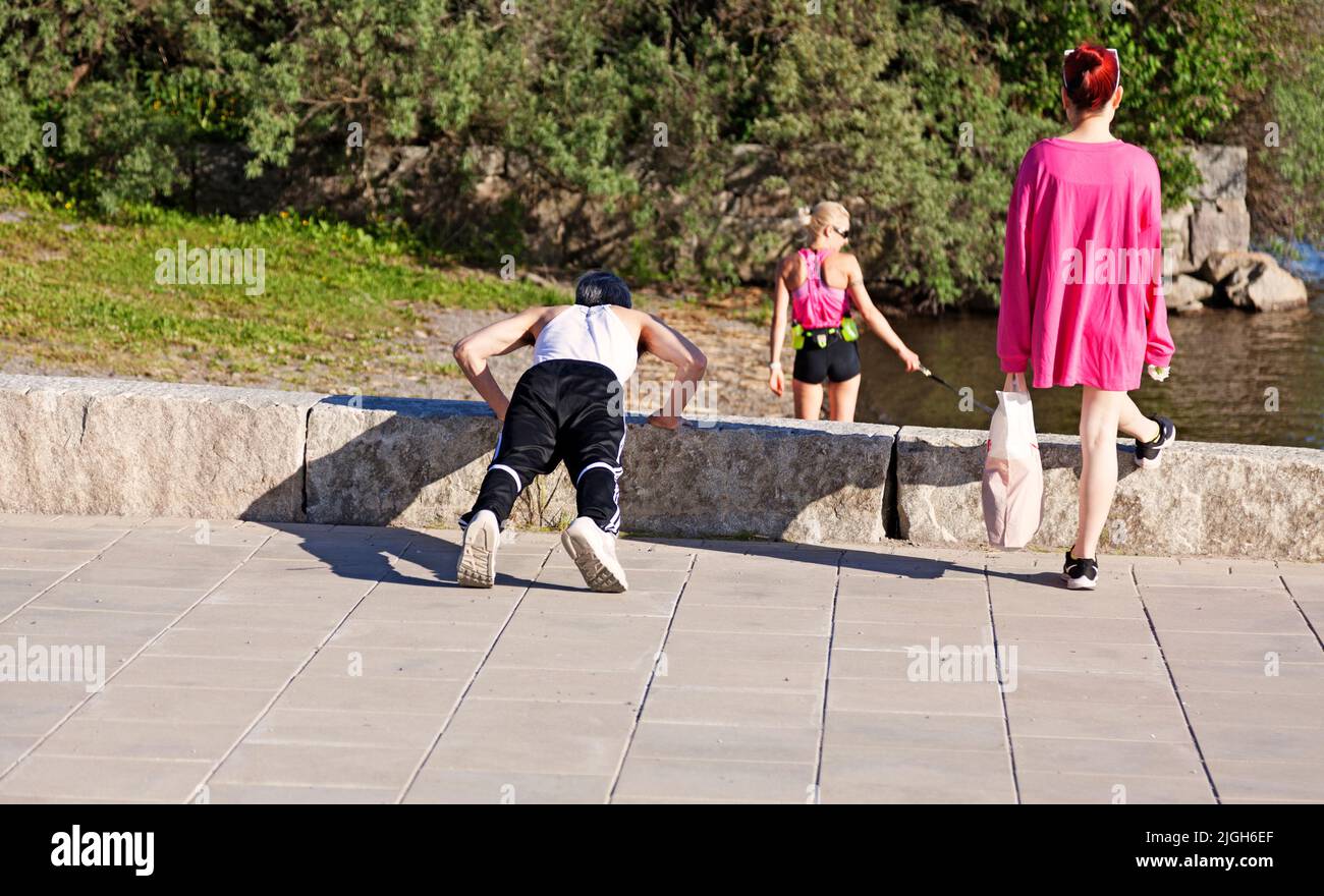 Vaasa, Finland - June 21, 2022: exerciser doing push-ups on the beach promenade Stock Photo